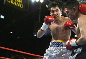 Las Vegas - June 22:  Marco Antonio Barrera (left) hits Erik Morales during the World Featherweight Championship fight at the MGM Grand Hotel/Casino in Las Vegas, Nevada on June 22, 2002.  Barrera defeated Morales by unanimous decision in 12 rounds and improved his record to 55-3 with 39 knockouts while Morales falls to 41-1 with 31 knockouts.  (Photo by Jed Jacobsohn/Getty Images)