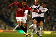 LONDON, ENGLAND - DECEMBER 19: Dimitar Berbatov of Manchester United holds off the challenge from Chris Baird of Fulham during the Barclays Premier League match between Fulham and Manchester United at Craven Cottage on December 19, 2009 in London, England. (Photo by Phil Cole/Getty Images)