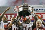 ATLANTA - DECEMBER 31:  Linebacker Cam Martin #41 and defensive end Nekos Brown #47 of the Virginia Tech Hokies hold the championship trophy as head coach Frank Beamer looks on after the Chick-Fil-A Bowl against the Tennessee Volunteers at the Georgia Dome on December 31, 2009 in Atlanta, Georgia.  The Hokies beat the Volunteers 37-14.  (Photo by Mike Zarrilli/Getty Images)