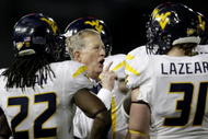 CINCINNATI - NOVEMBER 13: Head coach Bill Stewart of the West Virginia Mountaineers meets with his team in the fourth quarter of the game against the Cincinnati Bearcats at Nippert Stadium on November 13, 2009 in Cincinnati, Ohio. (Photo by Andy Lyons/Getty Images)