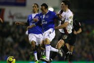 LIVERPOOL, ENGLAND - JANUARY 16:   Landon Donovan of Everton holds off the challenge of Gareth Barry of Manchester City during the Barclays Premier League match between Everton and Manchester City at Goodison Park on January 16, 2010 in Liverpool, England. (Photo by Alex Livesey/Getty Images)