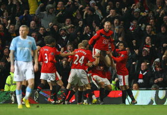 MANCHESTER, ENGLAND - JANUARY 27:  Michael Carrick of Manchester United celebrates scoring his team's second goal with Wayne Rooney and his team mates during the Carling Cup Semi Final second leg match between Manchester United and Manchester City at Old Trafford on January 27, 2010 in Manchester, England.  (Photo by Alex Livesey/Getty Images)