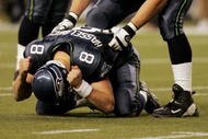 SEATTLE - JANUARY 8:   Lineman Jerry Wunsch #70 of the Seattle Seahawks helps a grieving quarterback Matt Hasselbeck #8 to his feet after Hasselbeck threw an incomplete pass into the endzone on their final offensive play as the Seahawks were defeated by the St. Louis Rams in the NFC wild-card game at Qwest Field on January 8, 2005 in Seattle, Washington. The Rams eliminated the Seahawks 27-20.  (Photo by Doug Benc/Getty Images)