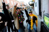 NEW ORLEANS - FEBRUARY 07:  (L-R) New Orleans Saints fans Raoul Duke, Jesse Brunet and Chrissie Brunet watch the Saints play against the Indianapolis Colts during Super Bowl XLIV on the sidewalk in the French Quarter on February 7, 2010 in New Orleans, Louisiana.  (Photo by Cheryl Gerber/Getty Images)