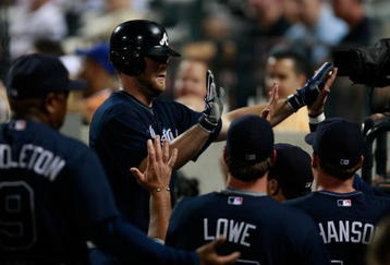 NEW YORK - AUGUST 20:  Brian McCann #16 of the Atlanta Braves is congratulated by teammates in the dugout after hitting a solo home run in the 4th inning against the New York Mets on August 20, 2009 at Citi Field in the Flushing neighborhood of the Queens borough of New York City.  (Photo by Jared Wickerham/Getty Images)