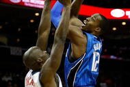 CHARLOTTE, NC - FEBRUARY 20: Dwight Howard #12 of the Orlando Magic shoots the ball over Emeka Okafor #50 of the Charlotte Bobcats during their game at Time Warner Cable Arena on February 20, 2009 in Charlotte, North Carolina. NOTE TO USER: User expressly acknowledges and agrees that, by downloading and/or using this Photograph, user is consenting to the terms and conditions of the Getty Images License Agreement. (Photo by Streeter Lecka/Getty Images)