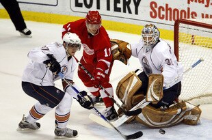 DETROIT - FEBRUARY 07:  Denis Grebeshkov #37 of the Edmonton Oilers tries to clear the puck from in front of Jeff Deslauriers #38 after a shot by Dan Cleary #11 the Detroit Red Wings during the second period on February 7, 2009 at Joe Louis Arena in Detroit, Michigan.  (Photo by Gregory Shamus/Getty Images)