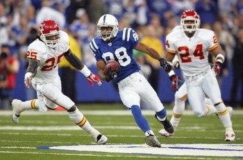 INDIANAPOLIS - JANUARY 06:  Marvin Harrison #88 of the Indianapolis Colts runs for yards after the catch on a 42-yard reception in the first quarter against Lenny Walls #25 and Ty Law #24 of the Kansas City Chiefs during their AFC Wild Card Playoff Game J
