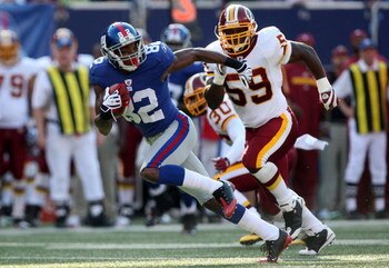 EAST RUTHERFORD, NJ - SEPTEMBER 13:  Mario Manningham #82 of the New York Giants runs the ball past London Fletcher #59 of the Washington Redskins on September 13, 2009 at Giants Stadium in East Rutherford, New Jersey.  (Photo by Jim McIsaac/Getty Images)