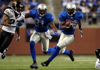 DETROIT - NOVEMBER 09:  Kevin Smith #34 of the Detroit Lions runs the ball as teammate Calvin Johnson #81 defends against Rashean Mathis #27 of the Jacksonville Jaguars on November 9, 2008 at Ford Field in Detroit, Michigan. Jacksonville defeated Detroit 