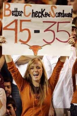 AUSTIN, TX - NOVEMBER 27:  A Texas Longhorn fan cheers on her team against the Texas A&M Aggies while holding a reminder of the Texas score against Oklahoma earlier in the season at Darrell K Royal-Texas Memorial Stadium November 27, 2008 in Austin, Texas