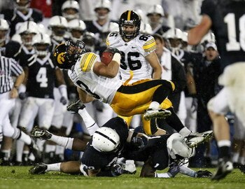 STATE COLLEGE, PA - SEPTEMBER 26:  Brandon Wegher #3 of the Iowa Hawkeyes is tackled by A.J. Wallace #1 and Drew Astorino #28 of the Penn State Nittnay Lions on September 26, 2009 at Beaver Stadium in State College, Pennsylvania. Iowa won the game 21-10. 