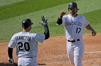 DENVER - OCTOBER 01:  Todd Helton #17 of the Colorado Rockies is welcomed home by Chris Iannetta #20 after he scored on an RBI double by Garrett Atkins off of starting pitcher Manny Parra #26 of the Milwaukee Brewers to give the Rockies a 3-0 lead in the 