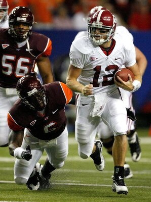 ATLANTA - SEPTEMBER 05:  Quarterback Greg McElroy #12 of the Alabama Crimson Tide rushes away from Jason Worilds #6 of the Virginia Tech Hokies during the Chick-fil-A Kickoff Game at Georgia Dome on September 5, 2009 in Atlanta, Georgia.  (Photo by Kevin 