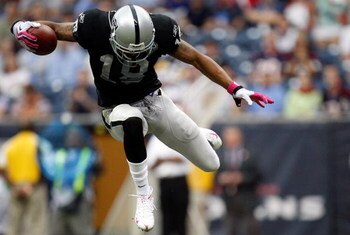 HOUSTON - OCTOBER 04:  Wide receiver Louis Murphy #18 of the Oakland Raiders jumps over a tackle by the Houston Texans at Reliant Stadium on October 4, 2009 in Houston, Texas.  (Photo by Ronald Martinez/Getty Images)