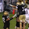 SOUTH BEND, IN - OCTOBER 03: Jimmy Clausen #7 of the Notre Dame Fighting Irish is lifted in the air by teammate Eric Olsen #55 as Paul Duncan #72 joins the celebration after a 4th quarter touchdown against the Washington Huskies on October 3, 2009 at Notr