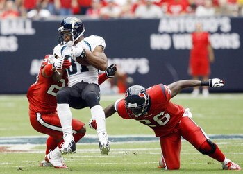 HOUSTON - SEPTEMBER 27: Wide receiver Torry Holt #81 of the Jacksonville Jaguars is tripped up by free safety Eugene Wilson #26 and cornerback Dunta Robinson #23 of the Houston Texans at Reliant Stadium on September 27, 2009 in Houston, Texas.  (Photo by 