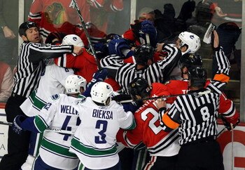 CHICAGO - MAY 05:  Officials attempt to seperate players from the Chicago Blackhawks and the Vancouver Canucks as they fight along the boards during the first period of Game Three of the Western Conference Semifinal Round of the 2009 Stanley Cup Playoffs 