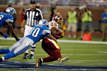 DETROIT, MI - SEPTEMBER 27: Running back Clinton Portis #26 of the Washington Redskins runs with the football as he is tackled by defensive back Ko Simpson #30 of the Detroit Lions at Ford Field on September 27, 2009 in Detroit, Michigan. The Lions defeat