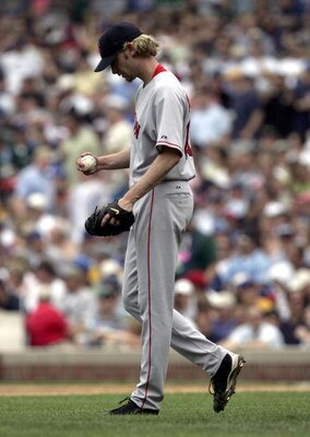 CHICAGO - JUNE 10:  Starting pitcher Bronson Arroyo #61 of the Boston Red Sox reacts after giving up runs in the third inning to the Chicago Cubs on June 10, 2005 at Wrigley Field in Chicago, Illinois. The Cubs defeated the Red Sox 14-6.  (Photo by Jonath