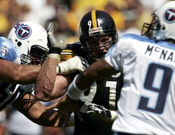 PITTSBURGH - SEPTEMBER 11: Aaron Smith #91 of the Pittsburgh Steelers rushes quarterback Steve McNair #9 of the Tennessee Titans as tackle Jacob Bell #60 attempts to block on September 11, 2005 at Heinz Field in Pittsburgh, Pennsylvania. The Steelers defe