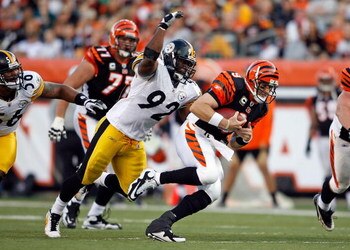 CINCINNATI - SEPTEMBER 27:  Carson Palmer #9 of the Cincinnati Bengals runs with the ball while defended by James Harrison #92 of the Pittsburgh Steelers at Paul Brown Stadium on September 27, 2009 in Cincinnati, Ohio.  The Bengals won 23-20.  (Photo by A