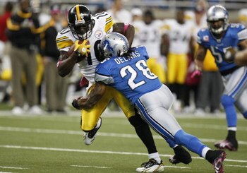 DETROIT - OCTOBER 11:  Santonio Holmes #10 of the Pittsburgh Steelers runs the ball as Louis Delmas #26 of the Detroit Lions goes for the tackle during their NFL game on October 11, 2009 at Ford Field in Detroit, Michigan. (Photo by Gregory Shamus/Getty I