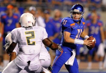 BOISE, ID - SEPTEMBER 3:  Kellen Moore #11 of the Boise State throws a pass under pressure by T.J. Ward #2 of the Oregon Ducks in second quarter of the game on September 3, 2009 at Broncos Stadium in Boise, Idaho. Boise State won the game 19-8. (Photo by 