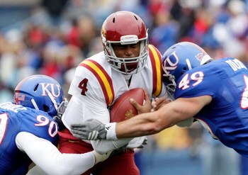 LAWRENCE, KS - OCTOBER 10:  Quarterback Austen Arnaud #4 of the Iowa State Cyclones is hit by Maxwell Onyegbule #90 and Drew Dudley #49 of the Kansas Jayhawks while scrambling during the game on October 10, 2009 at Memorial Stadium in Lawrence, Kansas.  (