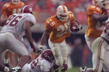 26 Oct 1996: Running back Jay Graham #25 of the Tennessee Volunteers tries to run through the tackle of defensive lineman Tyrell Buckner #92 of the Alabama Crimson Tide as defense lineman Michael Myers #96 closes during the Volunteers 20-13 victory over t