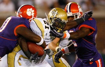 ATLANTA - SEPTEMBER 10:  Running back Jonathan Dwyer #21 of the Georgia Tech Yellow Jackets rushes upfield against Andre Branch #40 and DeAndre McDaniel #2 of the Clemson Tigers at Bobby Dodd Stadium on September 10, 2009 in Atlanta, Georgia.  (Photo by K