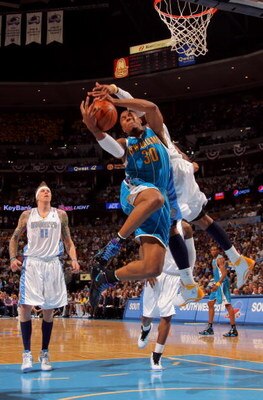 DENVER - APRIL 29:  David West #30 of the New Orleans Hornets is fouled by Carmelo Anthony #15 of the Denver Nuggets in Game Five of the Western Conference Quarterfinals during the 2009 NBA Playoffs at Pepsi Center on April 29, 2009 in Denver, Colorado. T