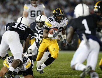 STATE COLLEGE, PA - SEPTEMBER 26:  Adam Robinson #32 of the Iowa Hawkeye's tries to find running room between Ollie Ogbu #85, Bani Gbadyu #15 and A.J. Wallace #1 of the Penn State Nittnay Lions on September 26, 2009 at Beaver Stadium in State College, Pen