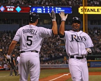 ST. PETERSBURG, FL - APRIL 13: Outfielder Carl Crawford #13 of the of the the Tampa Bay Rays celebrates a score with designated hitter Pat Burrell #5 against the New York Yankees April 13, 2009 in St. Petersburg, Florida.  (Photo by Al Messerschmidt/Getty