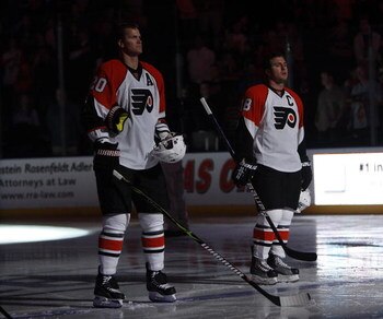 SUNRISE, FL - OCTOBER 16: Chris Pronger #20 and Mike Richards #18 of the Philadelphia Flyers stand during the playing of the national anthem prior to the game against the Florida Panthers on October 16, 2009 at the BankAtlantic Center in Sunrise, Florida.