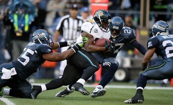 SEATTLE - OCTOBER 11:  Running back Maurice Jones-Drew #32 of the Jacksonville Jaguars rushes against Darryl Tapp #55 and Jordan Babineaux #27 of the Seattle Seahawks on October 11, 2009 at Qwest Field in Seattle, Washington. The Seahawks defeated the Jag