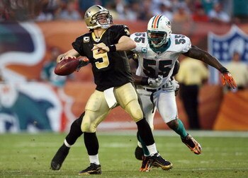 MIAMI - OCTOBER 25:  Quarterback Drew Brees #9 of the New Orleans Saints throws a pass before being hit by linebacker Joey Porter #55 of the Miami Dolphins at Land Shark Stadium on October 25, 2009 in Miami, Florida. The Saints defeated the Dolphins 46-34