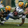 GREEN BAY, WI - OCTOBER 18: Kevin Smith #34 of the Detroit Lions is tackled by Ryan Pickett #79 and A.J. Hawk #50 of the Green Bay Packers at Lambeau Field on October 18, 2009 in Green Bay, Wisconsin. The Packers defeated the Lions 26-0. (Photo by Jonatha
