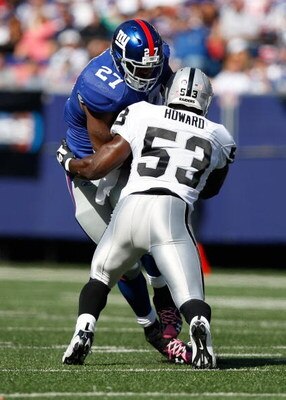EAST RUTHERFORD, NJ - OCTOBER 11: Brandon Jacobs #27 of the New York Giants runs through Thomas Howard #53 of the Oakland Raiders during the game on October 11, 2009 at Giants Stadium in East Rutherford, New Jersey.  (Photo by Jared Wickerham/Getty Images