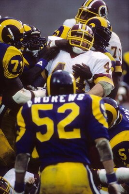 WASHINGTON - NOVEMBER 20:  Running back John Riggins #44 of the Washington Redskins is tackled by the defense of the Los Angeles Rams during the game at RFK Stadium on November 20, 1983 in Washington, D.C.  The Redskins won 42-20.  (Photo by George Rose/G