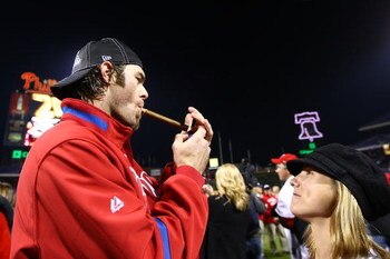 PHILADELPHIA - OCTOBER 21:  Jayson Werth #28 of the Philadelphia Phillies lights a cigar as his wife Julia watches after the Phillies won 10-4 against the Los Angeles Dodgers in Game Five of the NLCS during the 2009 MLB Playoffs at Citizens Bank Park on O