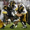 STATE COLLEGE, PA - SEPTEMBER 26:  Evan Royster #22 of the Penn State Nittnay Lions is tackled by Karl Klug #95, Tyler Sash #9, and Broderick Binns #91 of the Iowa Hawkeye's on September 26, 2009 at Beaver Stadium in State College, Pennsylvania. Iowa won 