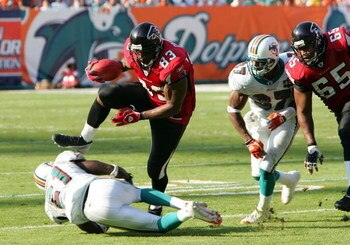 MIAMI - NOVEMBER 6:  Tight end Alge Crumpler #83 of the Atlanta Falcons jumps over cornerback Travis Daniels #21 of the Miami Dolphins after a pass reception on November 6, 2005 at Dolphins Stadium in Miami, Florida. The Falcons defeated the Dolphins 17-1