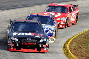 MARTINSVILLE, VA - OCTOBER 25:  Denny Hamlin, driver of the #11 FedEx Freight Toyota, leads David Reutimann, driver of the #00 Aaron's Dream Machine Toyota, and Juan Pablo Montoya, driver of the #42 Target Chevrolet, during the NASCAR Sprint Cup Series TU
