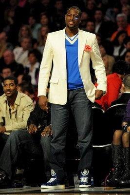 PHOENIX - FEBRUARY 14:  Dwyane Wade of the Miami Heat watches teammate Daequan Cook of the Heat participate in the Foot Locker Three-Point Shootout on All-Star Saturday Night, part of 2009 NBA All-Star Weekend at US Airways Center on February 14, 2009 in 