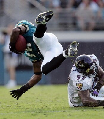 JACKSONVILLE, FL - NOVEMBER 13:  Linebacker Bart Scott #57 of the Baltimore Ravens trips up Ernest Wilford #19 of the Jacksonville Jaguars at Alltel Stadium November 13, 2005 in Jacksonville, Florida.  (Photo by Doug Benc/Getty Images)