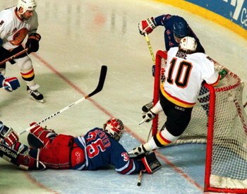 11 Jun 1994: PAVEL BURE HANGS ON THE CROSS BAR TO AVOID DIVING RANGERS GOALTENDER MIKE RICHTER DURING THE FIRST PERIOD OF GAME SIX OF THE STANLEY CUP FINALS IN VANCOUVER, BRITISH COLUMBIA.