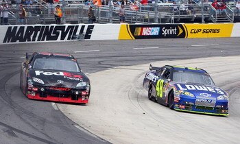 MARTINSVILLE, VA - MARCH 29:  Jimmie Johnson, driver of the #48 Lowe's Chevrolet, passes Denny Hamlin, driver of the #11 FedEx Express Toyota, at turn four late during the NASCAR Sprint Cup Series Goody's Fast Pain Relief 500 at the Martinsville Speedway 