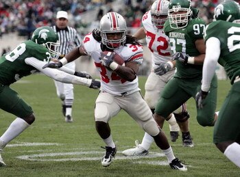 EAST LANSING, MI - OCTOBER 14:  Maurice Wells #34 of the Ohio State Buckeyes looks for a opening after getting around the tackle of Kendell Davis-Clark #38 and Joe Toth #97 of the Michigan State Spartans on October 14, 2006 at Spartan Stadium in East Lans
