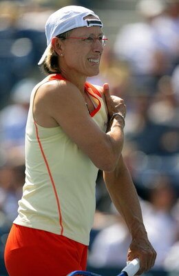 NEW YORK - SEPTEMBER 07:  Martina Navratilova grabs her arm while playing with Nadia Petrova of Russia against Samantha Stosur of Australia and Lisa Raymond during the U.S. Open at the USTA Billie Jean King National Tennis Center in Flushing Meadows Coron